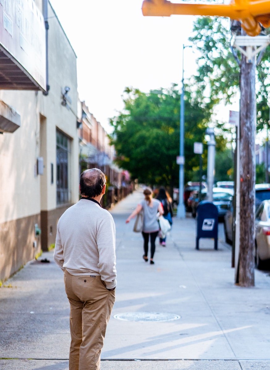 man standing outside looking forward his wife and child after divorce